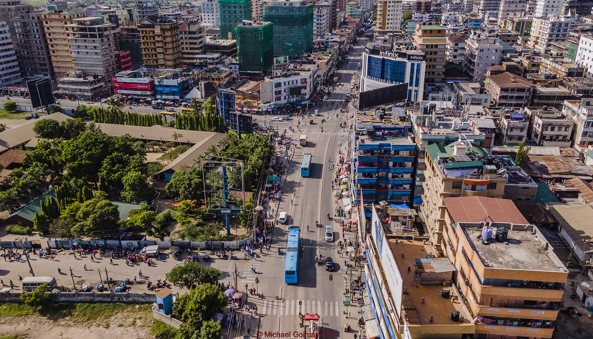 Aerial view of a major urban avenue lined with buildings, shops and buses, illustrating the density and vibrancy of a growing African city.