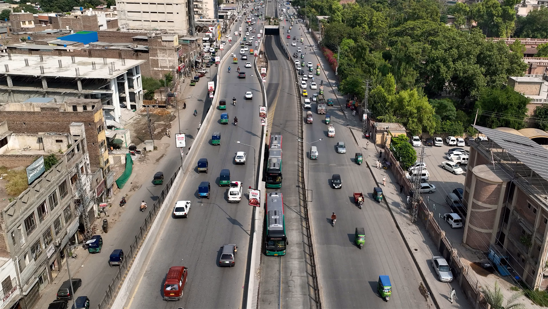 Vue aérienne d’une grande avenue urbaine avec circulation automobile et couloir central réservé aux bus.
