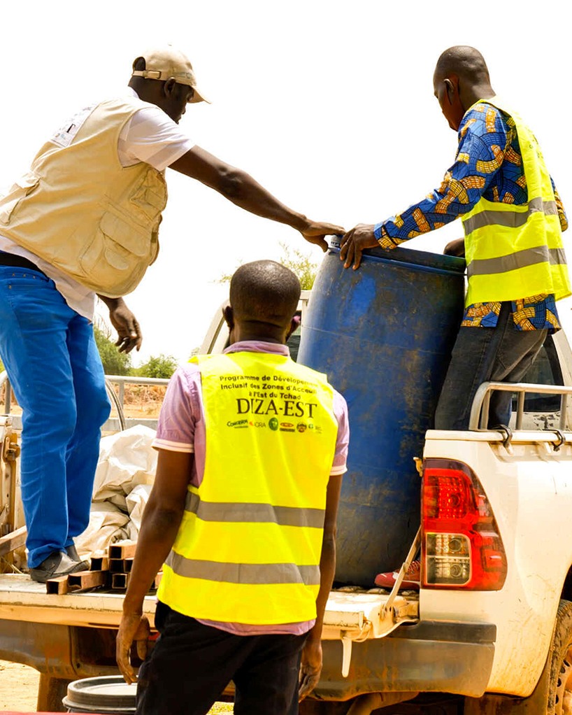 Men wearing Diza-Est tunics loading a vehicle